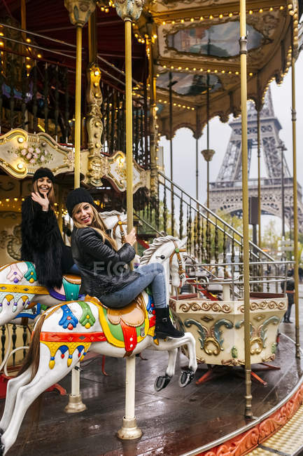 Parigi, Francia, due migliori amici a cavallo di una giostra con la Torre Eiffel sullo sfondo
. — Foto stock