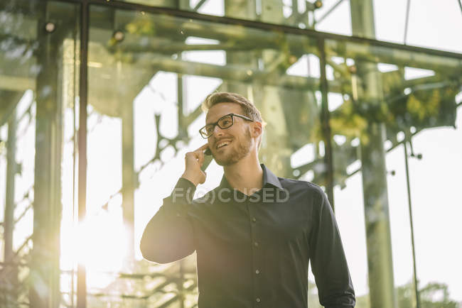 Portrait of businessman using smartphone indoors — Stock Photo
