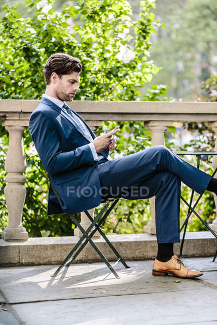 Businessman sitting on garden chair — Stock Photo