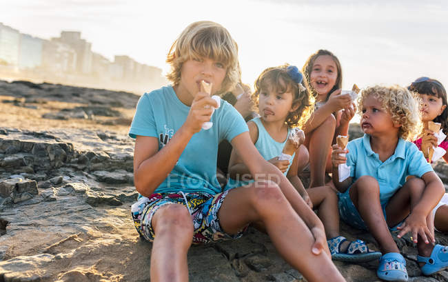 Gruppo di bambini che mangiano un gelato sulla spiaggia, Gijn, Asturie, Spagna — Foto stock