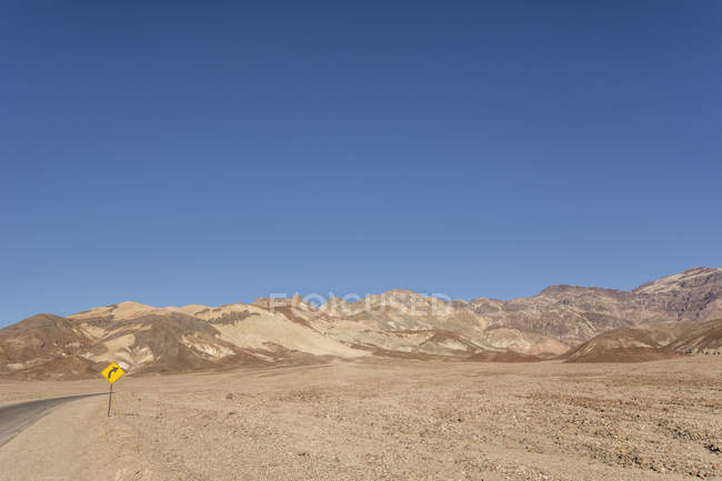 USA, California, Death Valley, deserto con strada vuota e cartello stradale — Foto stock
