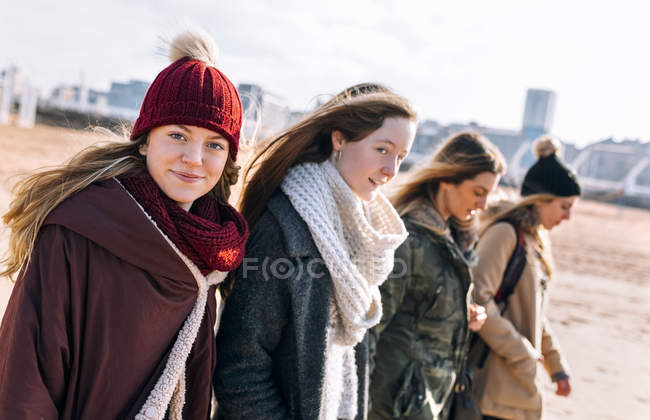 Quattro giovani donne che passeggiano in spiaggia in inverno — Foto stock