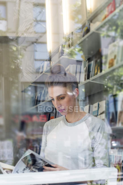 Жінка читання книги в книжковому магазині — стокове фото