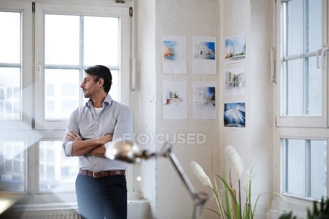 Nachdenklicher Mann schaut im Büro aus dem Fenster — Stockfoto