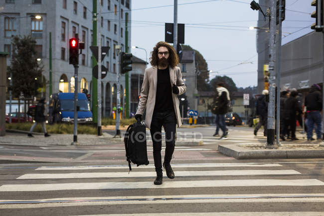 Uomo con borsa attraversando strada — Foto stock
