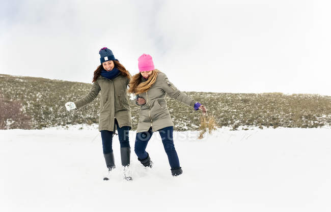Asturias, Spain, two friends having fun in the snow — Stock Photo