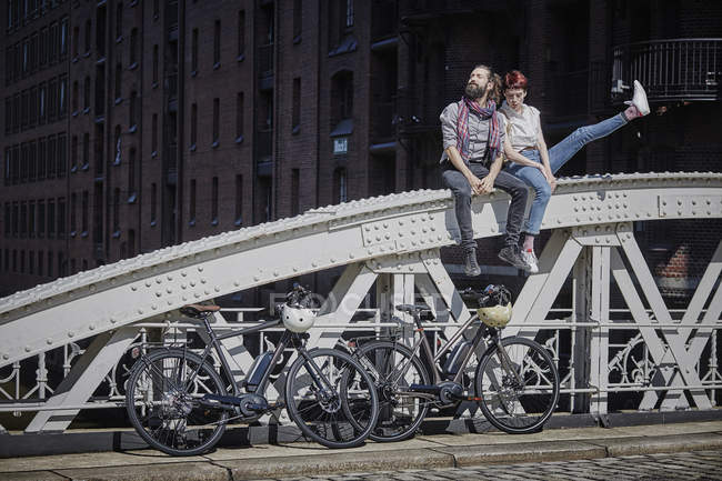 Portrait de cyclistes couple reposant sur le pont — Photo de stock