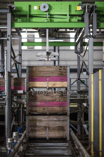 Group of crates stacked on machine in factory — Stock Photo