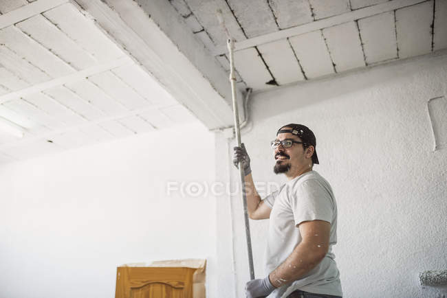 Smiling Man Painting Ceiling Of A Garage Color Image