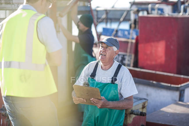 Професійні кавказька рибалка на траулер розмовляти з інспектор — стокове фото