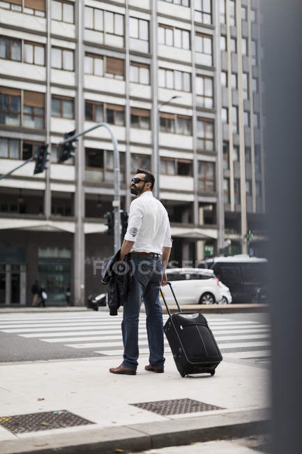 Uomo d'affari con valigia in città — Foto stock