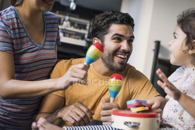 Щаслива родина разом, граючи з іграшкою маракаси — стокове фото