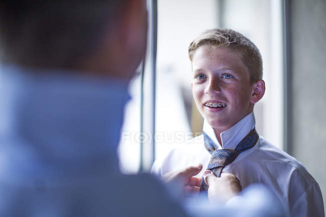 Молодий хлопчик отримує допомогу з краваткою був закріплений — стокове фото