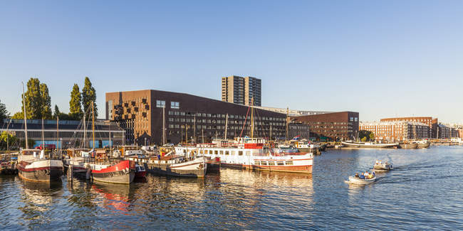 Pays-Bas, Amsterdam, Île KNSM avec immeuble du Pirée et péniches au premier plan — Photo de stock