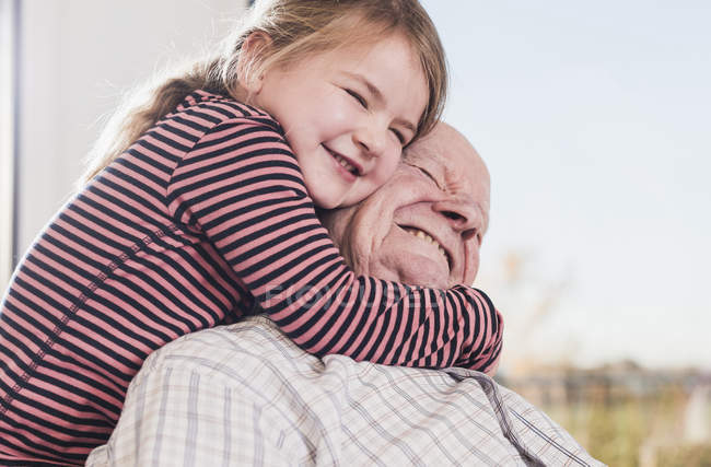 Primer plano de abuelo abrazo nieta delante de ventana — ojos ...