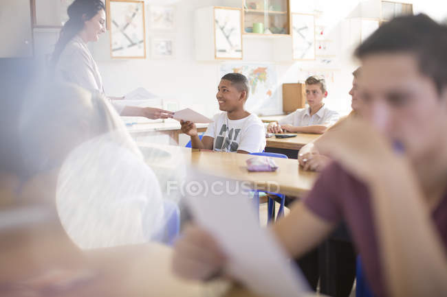Усміхаючись студент отримує результати випробувань в класі — стокове фото