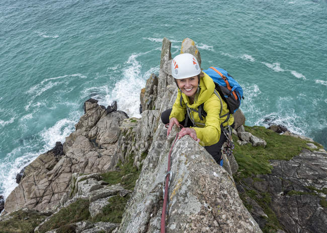 Reino Unido, Cornualha, mulher sorridente escalando em Commando Ridge — Fotografia de Stock