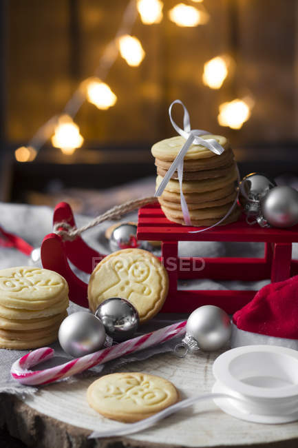 Рождественское украшение с миниатюрными санями и песочным хлебом — стоковое фото