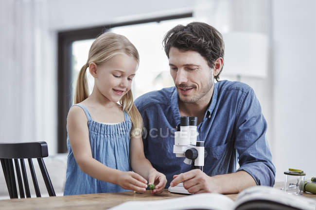 Батько і дочка вивчення з Бінокулярний вдома — стокове фото
