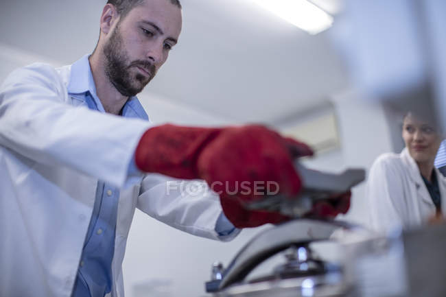 Uomo che lavora in laboratorio indossando indumenti protettivi — Foto stock