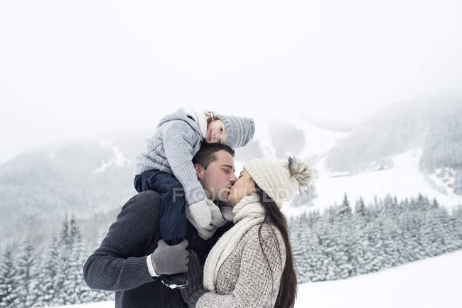 Couple avec fille embrasser dans le paysage d'hiver — Photo de stock