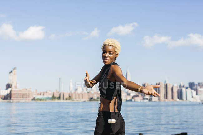 USA, New York City, Brooklyn, jeune Africaine souriante à East River — Photo de stock