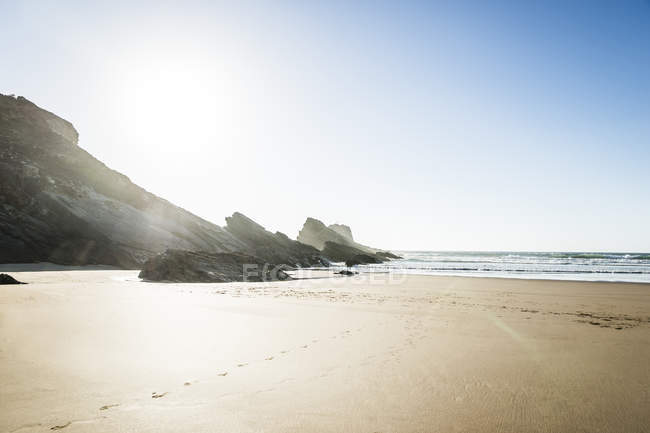 Portugal, Alentejo, Rocks and footprints at Zambujeira do Mar beach — Stock Photo