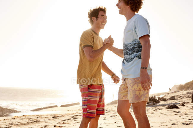 Deux jeunes hommes heureux sur la plage — Photo de stock