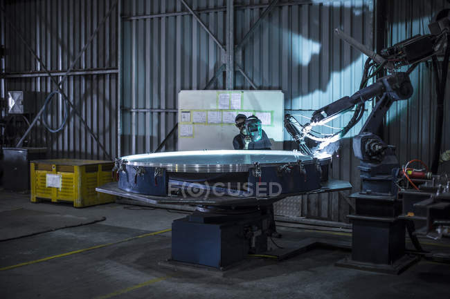 Soudeur debout derrière l'acier de coupe de tour industriel dans l'usine — Photo de stock
