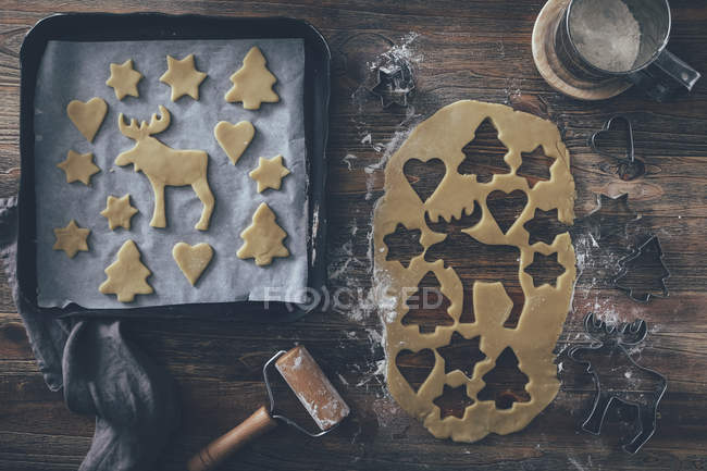 Christmas bakery, cookies on metal tray and shaped dough top view — Stock Photo
