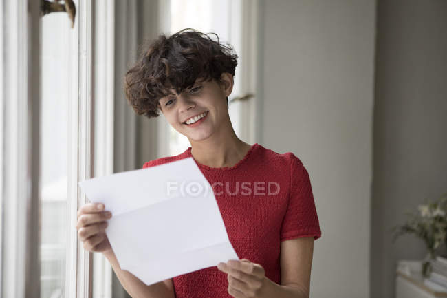 Jeune femme souriante lisant une lettre — Photo de stock