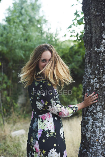 Sorrindo mulher loira vestindo vestido com design floral — Fotografia de Stock