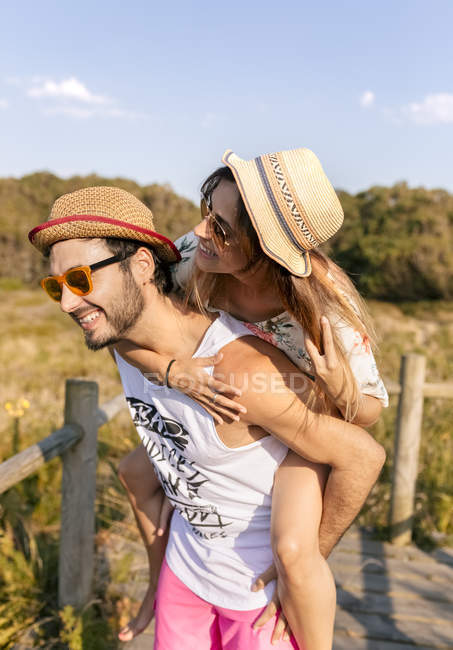 Молода пара весело в лузі недалеко від узбережжя на заході сонця — стокове фото