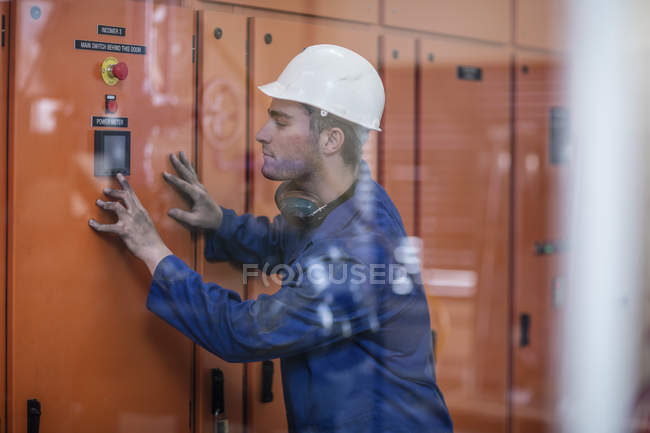 Worker operating machine in factory — Stock Photo