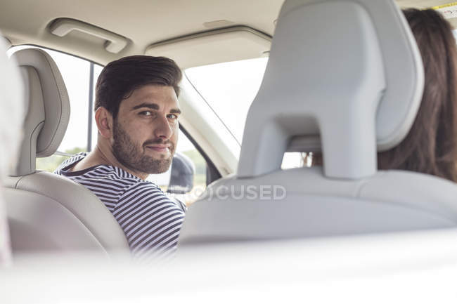 Homme conduisant en voiture et regardant la caméra — Photo de stock