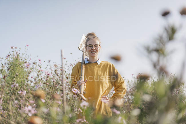 Sorrindo jovem com pá no jardim da casa de campo — Fotografia de Stock