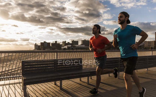 США, Нью-Йорк, двое мужчин бегут по Кони-Айленду — стоковое фото