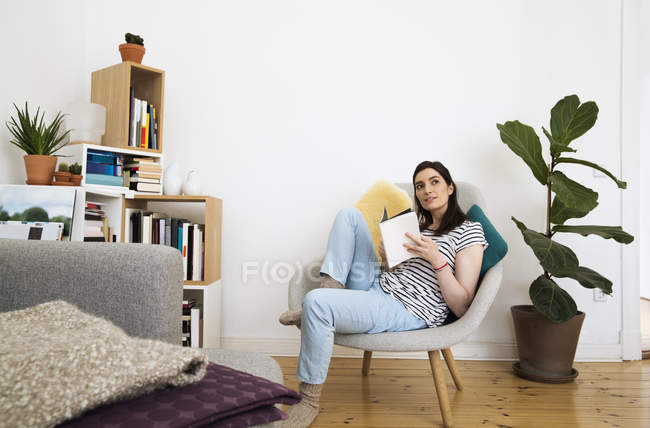 Beautiful caucasian brunette woman reading book at home — Stock Photo