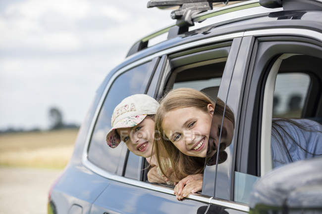 Mädchen sitzen im Auto und schauen aus dem Fenster — Stockfoto