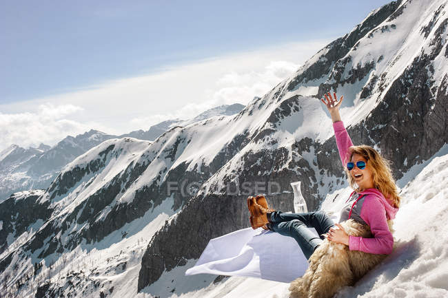 Jeune femme assise à table couchée dans les montagnes — Photo de stock
