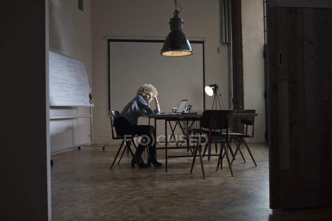 Erschöpfte Frau sitzt am Konferenztisch im Sitzungssaal — Stockfoto