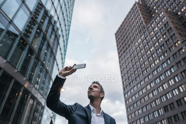 Germania, Berlino, uomo d'affari che si fa selfie con smartphone — Foto stock