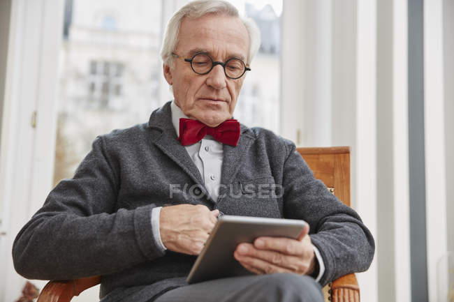 Senior Man Sitting On Chair Holding Tablet One Person Bow Tie