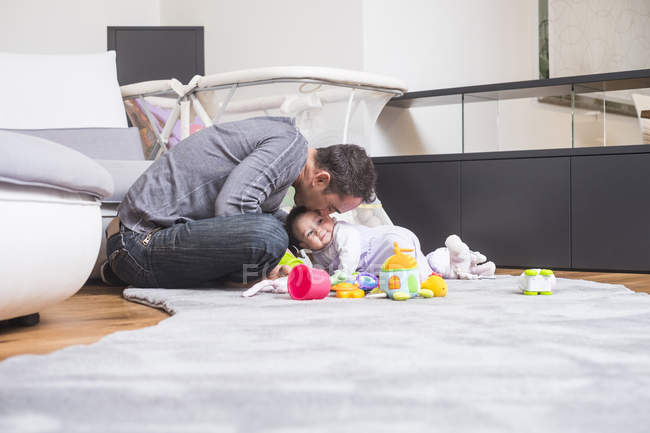 Père avec bébé fille jouant sur le sol à la maison — Photo de stock