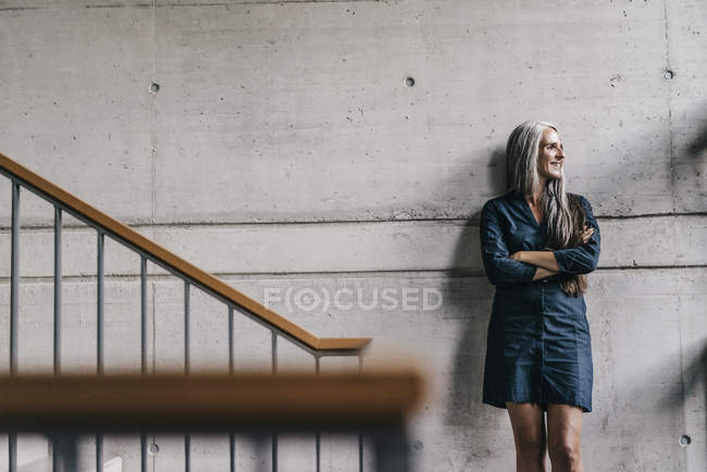 Mulher sorridente com longos cabelos grisalhos em escadaria — Fotografia de Stock