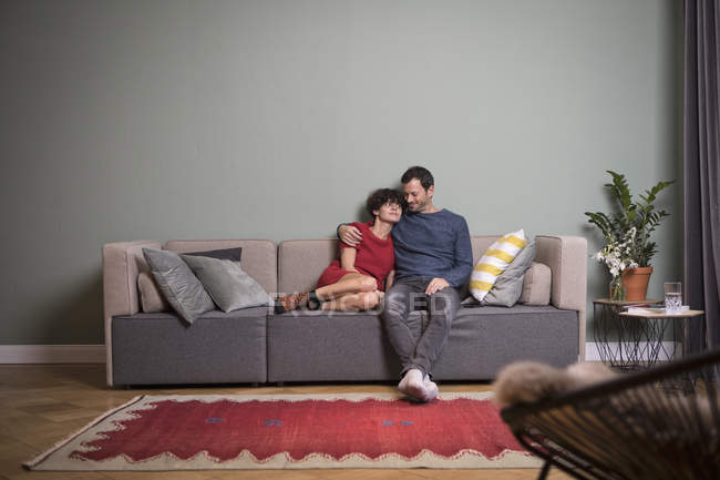 Couple Sitting Together On The Couch In Modern Apartment Furniture Carpet Stock Photo 173589002