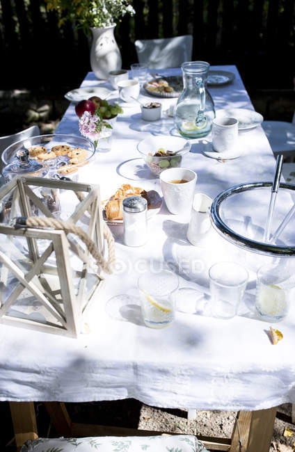 Оформлені у сільському стилі накритий стіл в саду — стокове фото