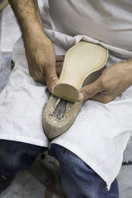 Чоботар, поклавши підошви взуття в його майстерні — стокове фото
