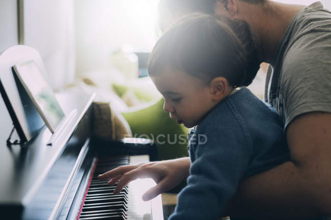Enfant et père jouant ensemble du piano — Photo de stock