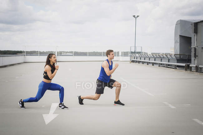 Homem e mulher fazendo lunges ao ar livre — Fotografia de Stock